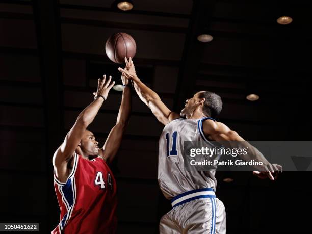 basketball player trying to take basketball from opponent - basket foto e immagini stock