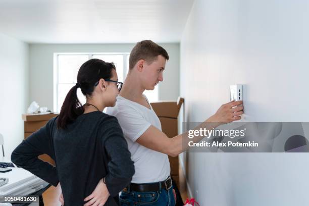 the young man teaching the 16-years-old teenage girl how to use the intercom in the new recently purchased apartment - girl doorbell stock pictures, royalty-free photos & images