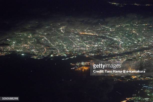 osaka bay and osaka city in osaka prefecture, and amagasaki and nishinomiya cities in hyogo prefecture in japan night time aerial view from airplane - amagasaki foto e immagini stock