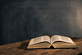 Bible on a old oak wooden table. Beautiful dark background.Religion concept