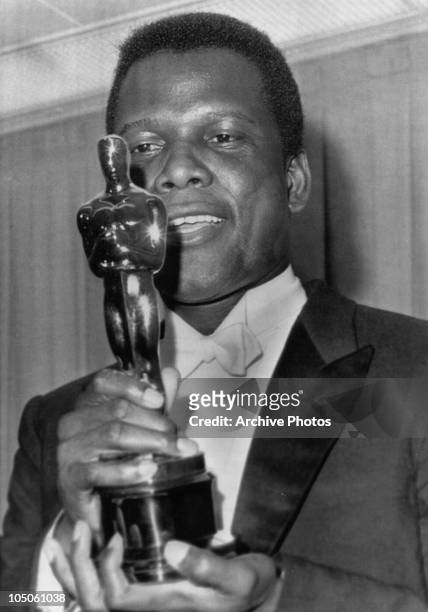 Bahamian American actor Sidney Poitier holding his Academy Award for Best Actor in a Leading Role for 'Lilies Of The Field', directed by Ralph...