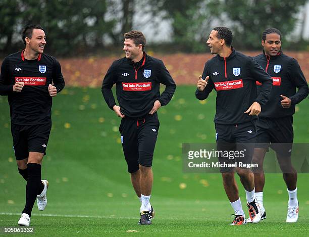 John Terry, Rio Ferdinand and Steven Gerrard warm up during the England training session at London Colney on October 8, 2010 in St Albans, England.