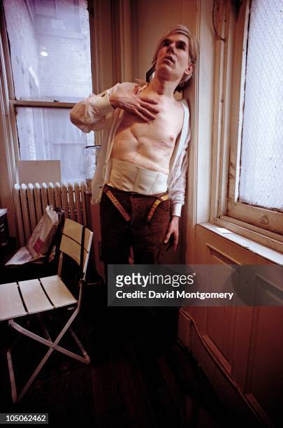 American pop artist Andy Warhol displays the scars on his torso, which resulted from being shot in an attempted assassination by radical feminist...