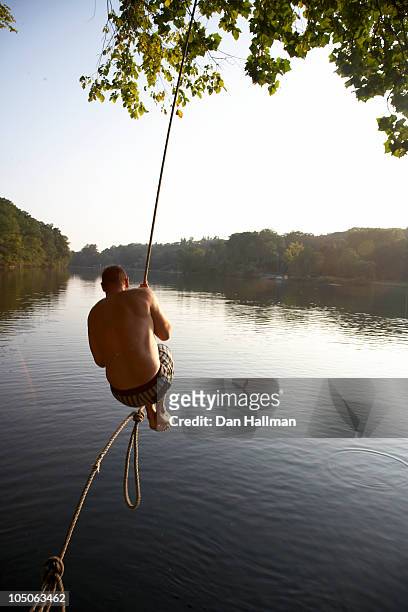 man on rope swing - rope swing stock pictures, royalty-free photos & images