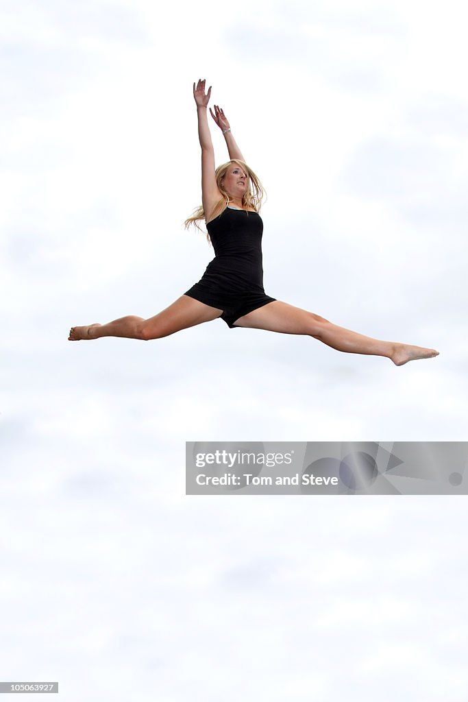 Girl does athletic high jump and splits