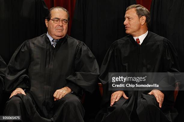 Supreme Court Associate Justice Antonin Scalia and Chief Justice John Roberts talk while posing for photographs in the East Conference Room at the...