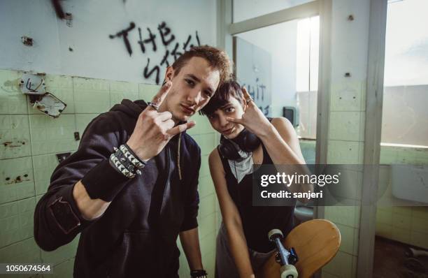 teenager couple hanging out in the ghetto - teenage rebellion stock pictures, royalty-free photos & images