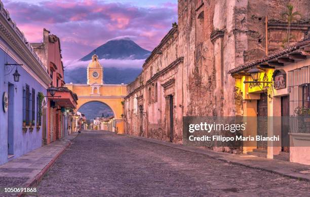 santa catalina arch, antigua, guatemala, at sunrise - volcán de agua fotografías e imágenes de stock