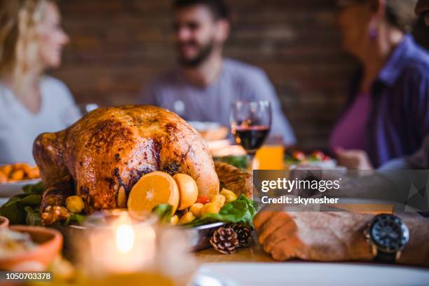 close up of roasted turkey on family's' dining table. - turkey meat stock pictures, royalty-free photos & images