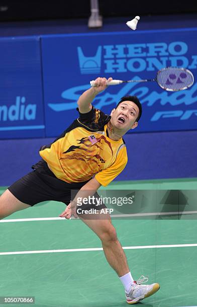 Badminton player Koo Kien Kat of Malaysia, alongside unseen partner Chin Eh Hui, returns a shot to opponents Jwala Gutta and Diju Valiya Veetil of...