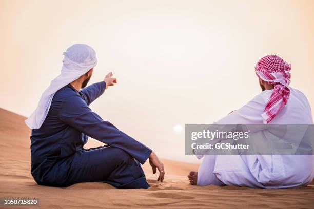 arab man pointing towards the horizon - qatar landscape stock pictures, royalty-free photos & images