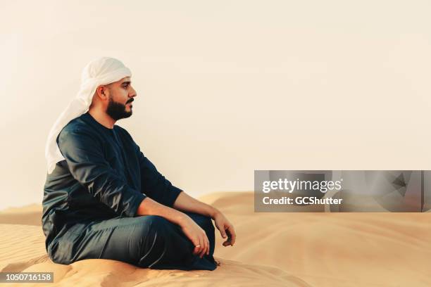 arab man admiring the sand dunes - bahrain tourism stock pictures, royalty-free photos & images