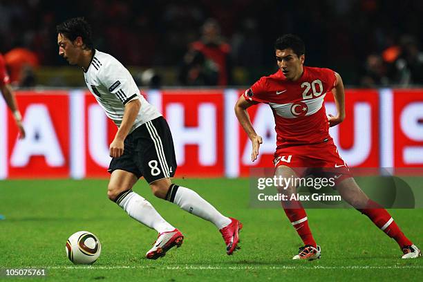 Mesut Oezil of Germany eludes Nuri Sahin of Turkey during the EURO 2012 group A qualifier match between Germany and Turkey at the Olympic Stadium on...