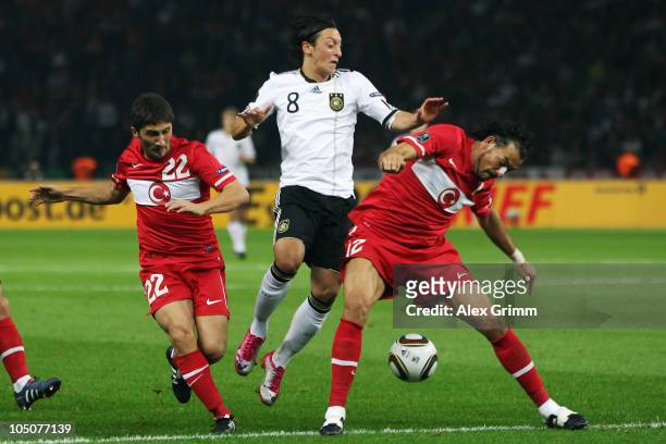 D8 of Germany is challenged by Sabri Sarioglu and Servet Cetin of Turkey during the EURO 2012 group A qualifier match between Germany and Turkey at...