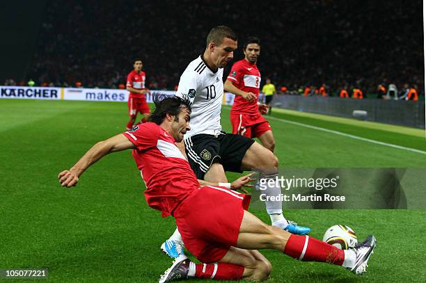 Lukas Podolski of Germany and Oemr Erdogan of Turkey compete for the ball during the EURO 2012 Group A qualifier match between Germany and Turkey at...