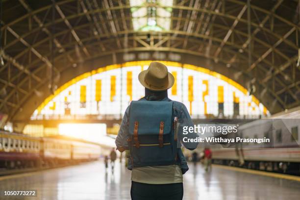 Young Asian traveling backpacker in railway station in Bangkok, Thailand