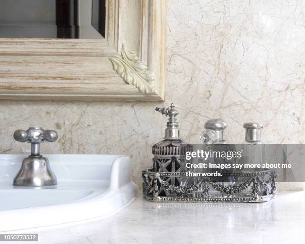 a silver tray with a collection of antique perfume bottles over a bathroom counter. still life. - deko bad stock-fotos und bilder