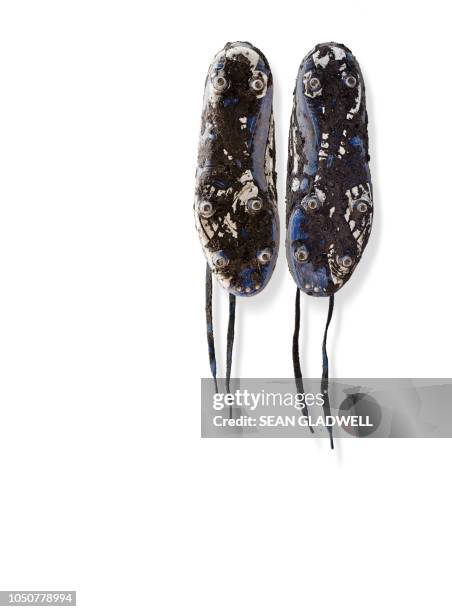 muddy football boots hanging - white boot stock pictures, royalty-free photos & images