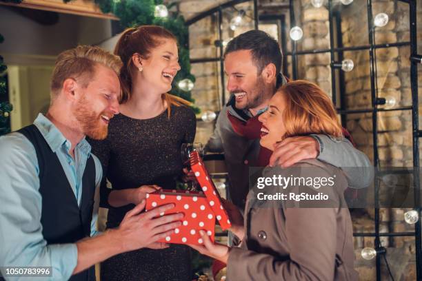 smiling people holding a present - housewarming gift stock pictures, royalty-free photos & images