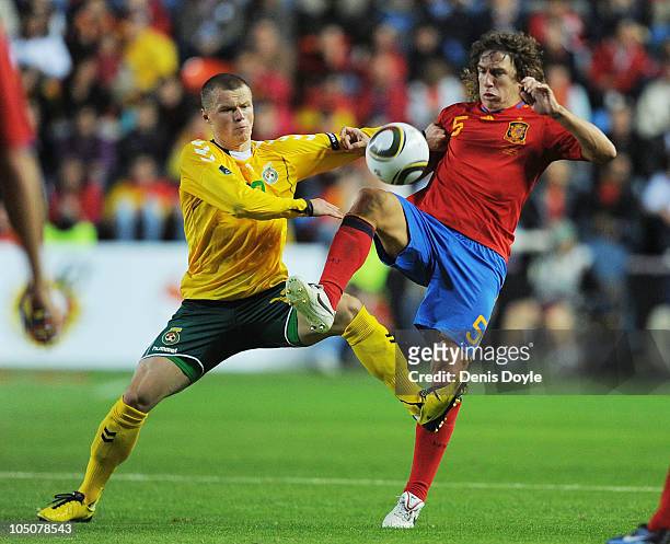 Carles Puyol of Spain clashes with Darvydas Sernas of Lithuania during the EURO 2012 Qualifying Group I match between Spain and Lithuania at the...