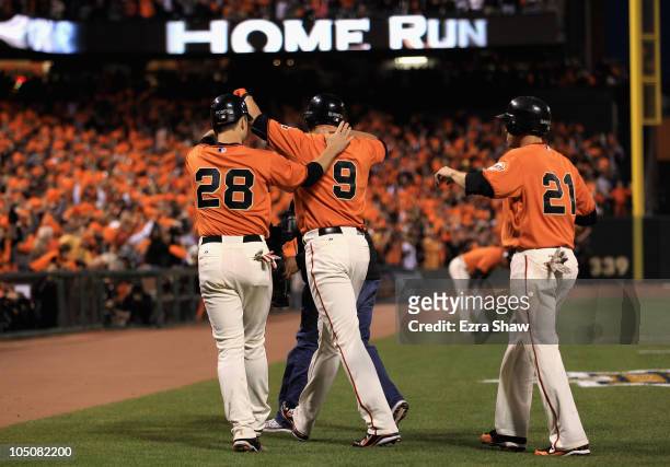Pat Burrell is congratulated by Buster Posey and Freddy Sanchez of the San Francisco Giants after he hit a three run home run in the first inning...