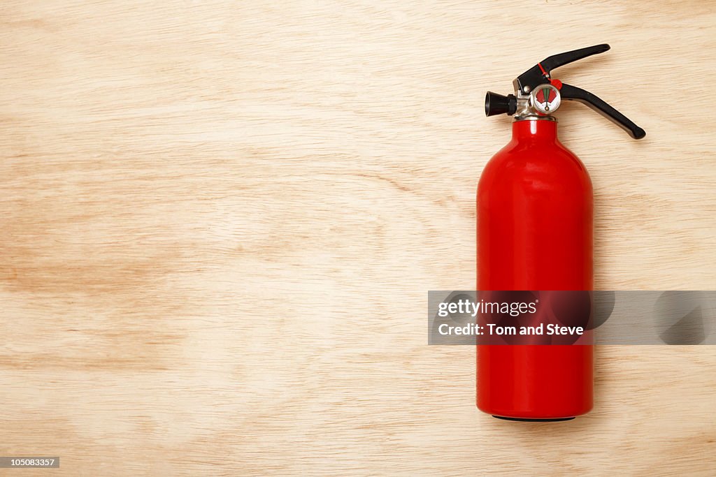 Fire Extinguisher On Wood Background