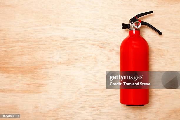 fire extinguisher on wood background - fire extinguisher stock pictures, royalty-free photos & images