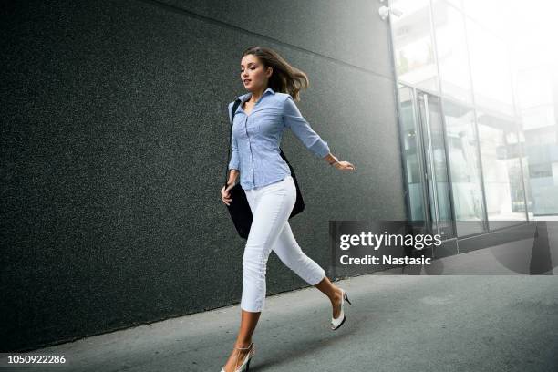 young fashionable business woman with long curly hair running - business woman movement dynamic stock pictures, royalty-free photos & images