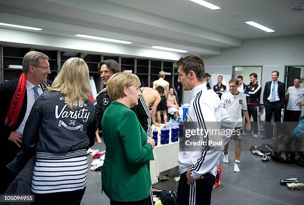 In this photo provided by the German Government Press Office, German Chancellor Angela Merkel chats with German national player Miroslav Klose next...