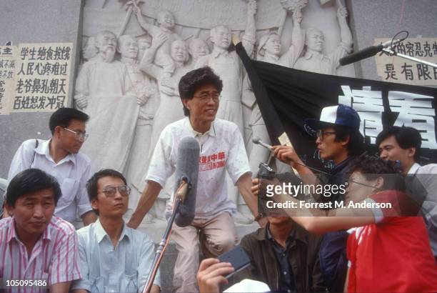 View of demonstrators gathered in Tiananmen Square where singer-composer Hou Dejian speaks; also seen are literary critic Liu Xiaobo , and...