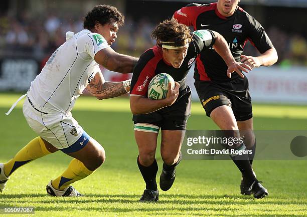 Derick Hougaard of Saracens is tackled by Sione Lauaki during the Heineken Cup match between ASM Clermont Auvergne and Saracens at Stade Marcel...