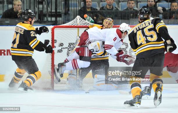 Scottie Upshall of the Phoenix Coyotes crashes into Tuukka Rask of the Boston Bruins at the O2 Arena on October 9, 2010 in Prague, Czech Republic.