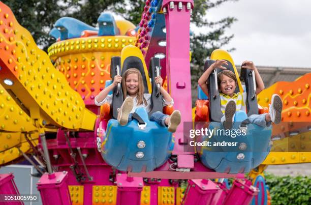 enfants heureux s’amuser dans un parc d’attractions - parc dattractions photos et images de collection