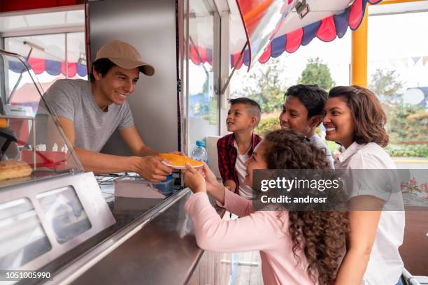 portrait of a happy family buying food at an amusement park - lifestyle concepts - food truck festival stock pictures, royalty-free photos & images