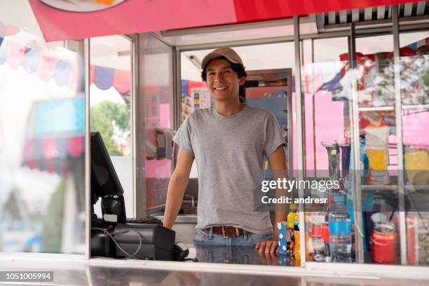 man verkoop van levensmiddelen in een vrachtwagen bij een pretpark - food stall stockfoto's en -beelden