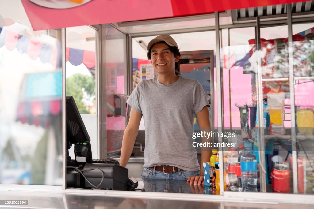 Man selling food in a truck at an amusement park