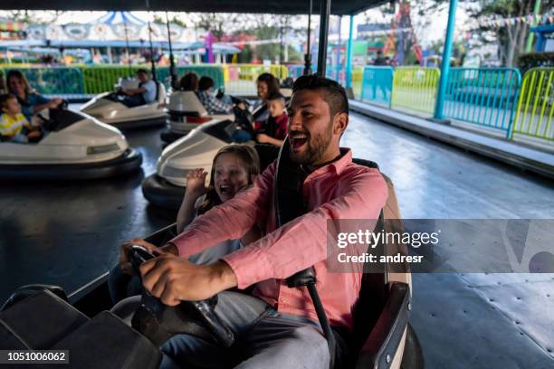 heureux père et fille s’amuser sur les autos tamponneuses à un parc d’attractions - parc dattractions photos et images de collection