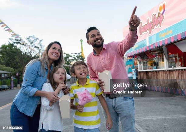 happy family having fun at an amusement park - cotton candy stock pictures, royalty-free photos & images