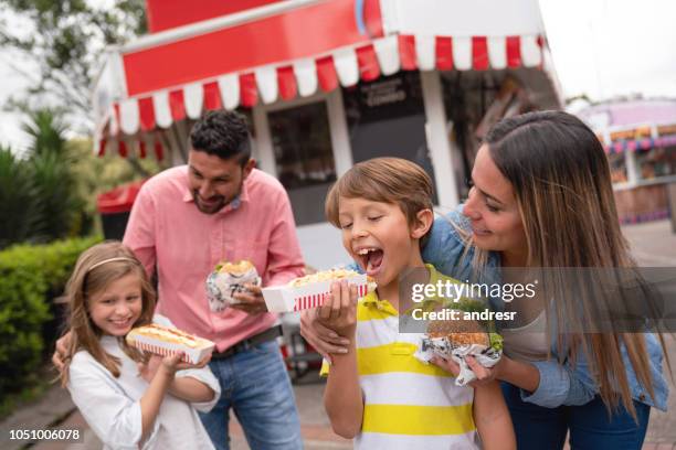 héhé, manger de la malbouffe à un parc d’attractions - parc dattractions photos et images de collection