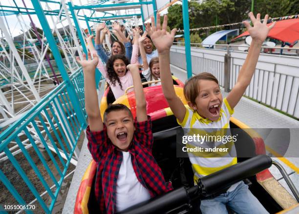 mycket glada barn att ha roligt på en berg-och dalbana i nöjesparken - rollercoaster kids bildbanksfoton och bilder