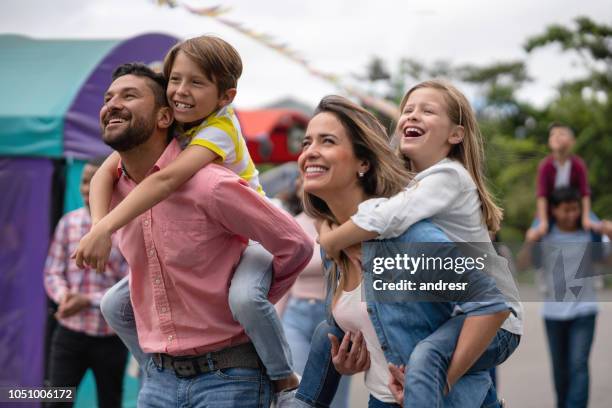 glückliche familie, die spaß an einem vergnügungspark - father son outdoor celebration stock-fotos und bilder