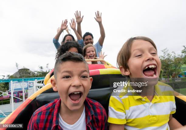 glada barn ha roligt i en nöjespark - rollercoaster kids bildbanksfoton och bilder