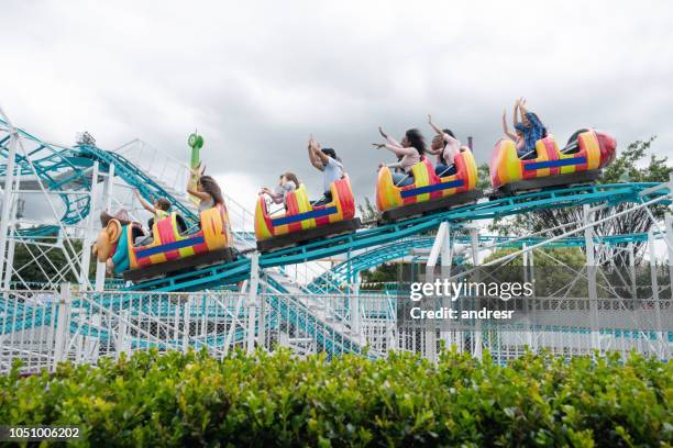 happy group of people having fun in an amusement park - young woman screaming on a rollercoaster stock pictures, royalty-free photos & images