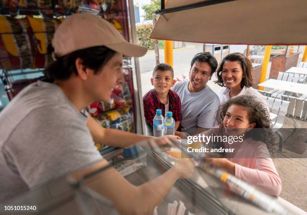 happy family buying food at an amusement park - food truck festival stock pictures, royalty-free photos & images