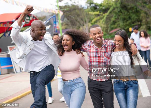 happy group of friends having fun at an amusement park - colombia festival stock pictures, royalty-free photos & images