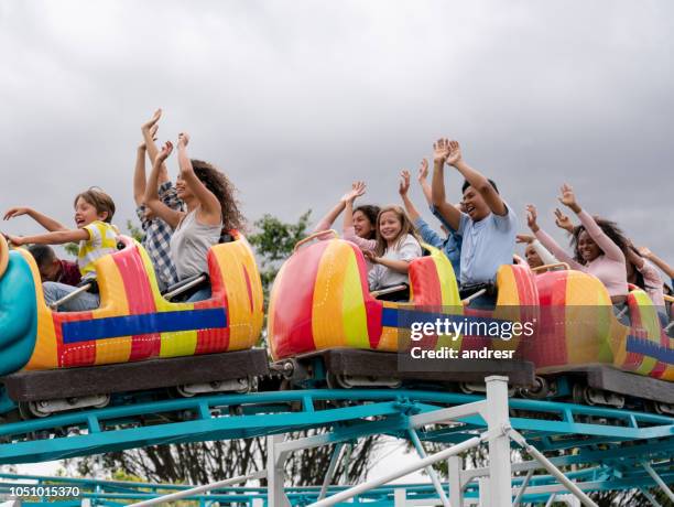 happy group of people having fun in a rollercoaster at an amusement park - young woman screaming on a rollercoaster stock pictures, royalty-free photos & images