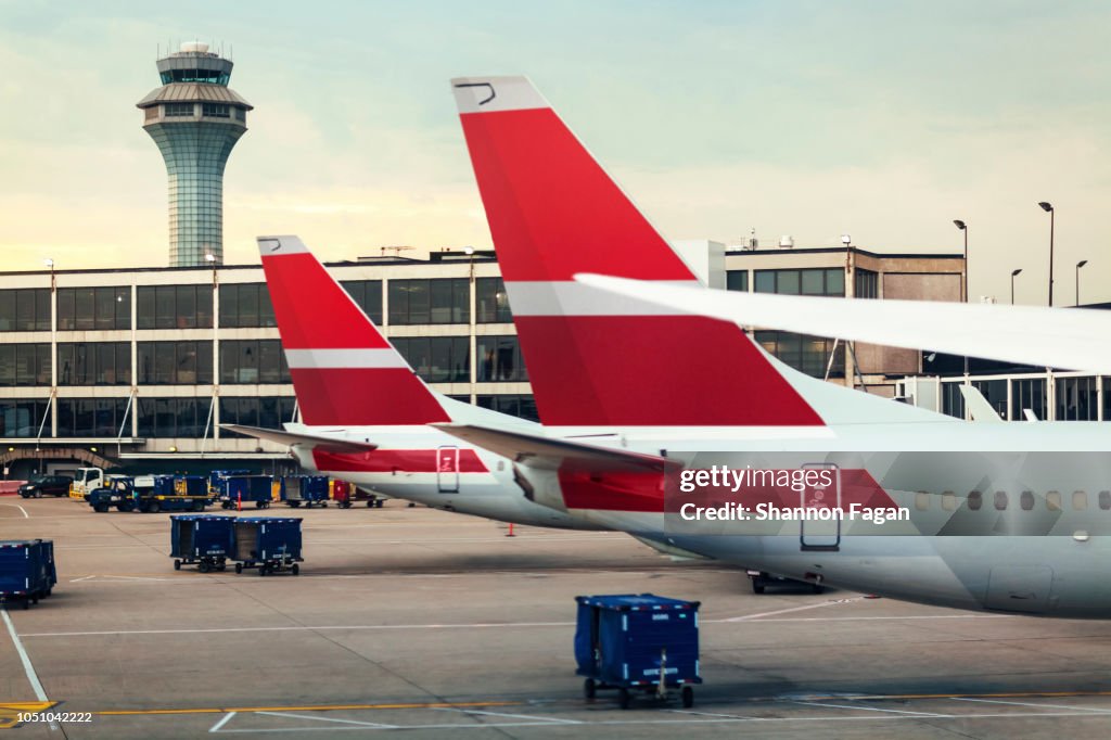 View of two airplane tails on tarmac at airport