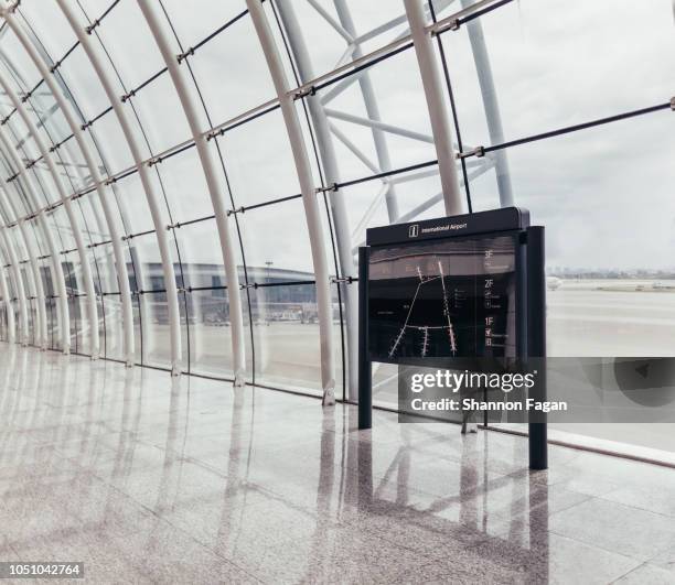 view of directory board in front of glass at airport - departure board front on stockfoto's en -beelden