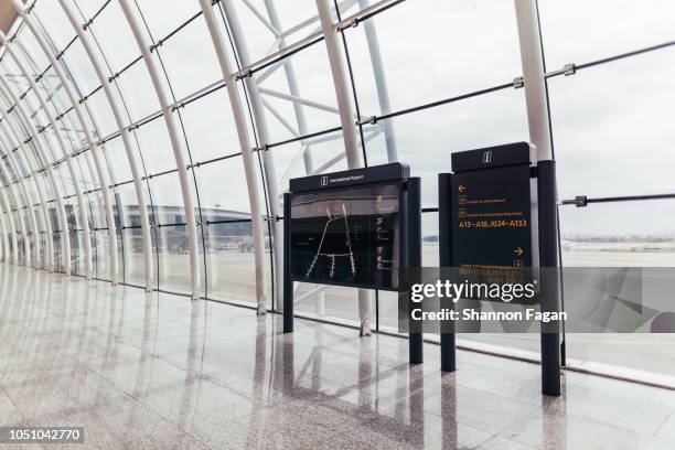 view of directory boards in front of glass at airport - departure board front on stockfoto's en -beelden