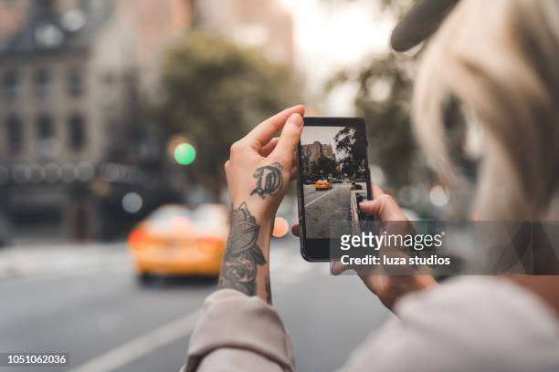 weibliche touristen in new york fotografieren mit telefon - fotografieren stock-fotos und bilder